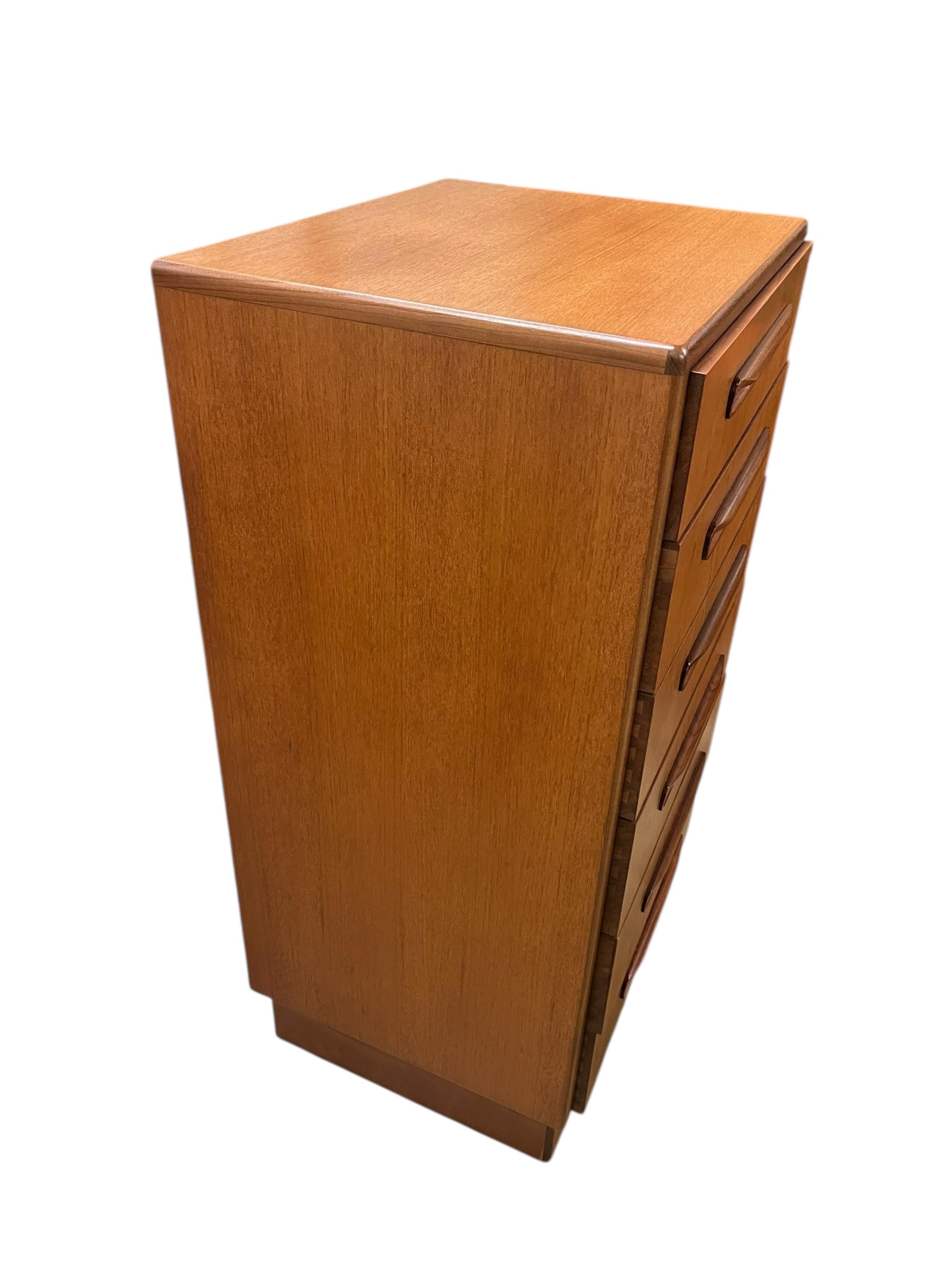 A mid century G Plan Fresco teak bedroom suite comprising a three door wardrobe, a two door wardrobe, two six drawer chests, dressing table, headboard and a pair of bedside chests